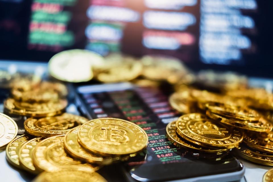 A smartphone buried under gold tokens.