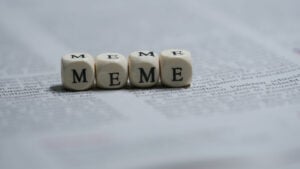 Four dice on a newspaper with letters instead of dots, which make up the word 