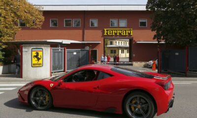 FILE PHOTO: A Ferrari sport car goes past in front of Ferrari