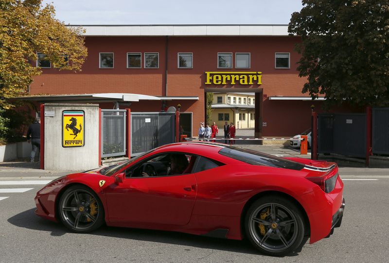 FILE PHOTO: A Ferrari sport car goes past in front of Ferrari